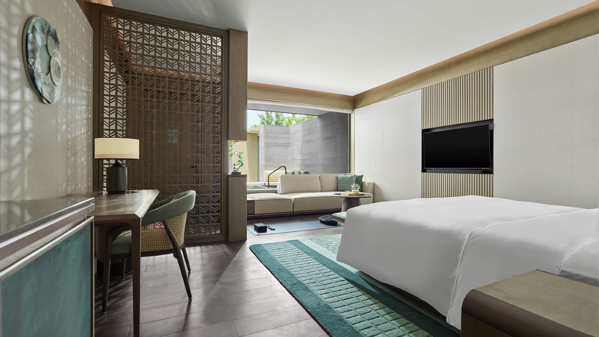 Luxurious room with a cozy bed, elegant desk, and outdoor view at Banyan Tree Suzhou Shishan.